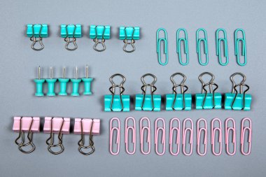 Gri arkaplandaki cilt klipsi ve ofis malzemeleri