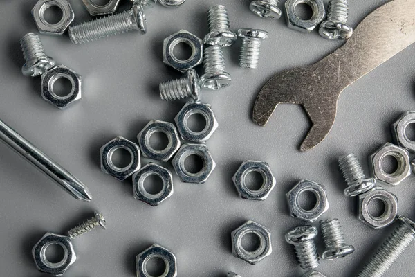Metal bolts and nuts in a gray background