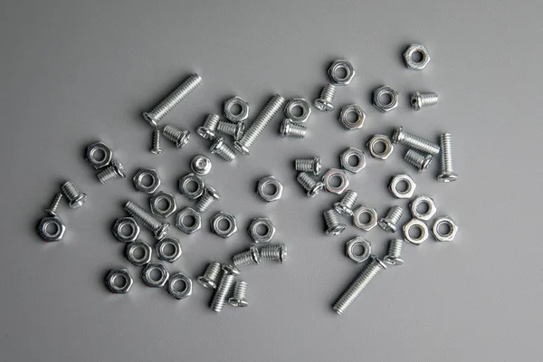 Metal bolts and nuts in a gray background