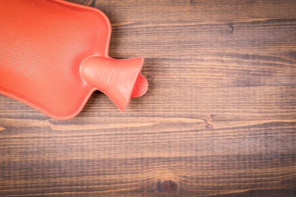 Bouteille d'eau chaude ou sac sur une table en bois — Photo