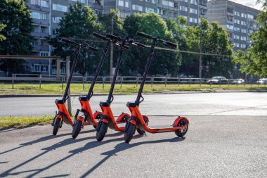 Sokağın kenarındaki elektrikli scooterlar. Mobil uygulamalar kullanılarak kiralanan yeni toplu taşıma hizmeti