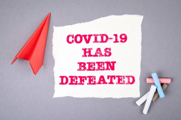 O COVID-19 foi derrotado. Texto na folha de notas, plano de papel, símbolo de ganhar objetivos — Fotografia de Stock