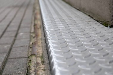 Metal zemin plakası. Çelik, inşaat, dekorasyon ve güvenlik. Asfalt kaldırım ve adım