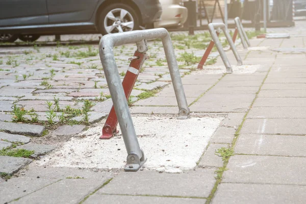 Barrera de aparcamiento en el lugar de estacionamiento, coches estacionados. Pavimento con hierba — Foto de Stock