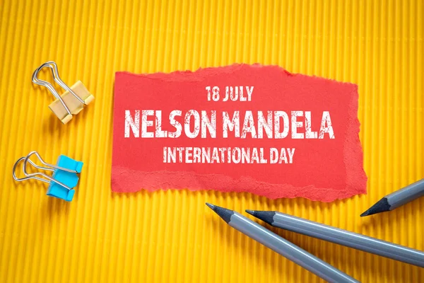 Nelson Mandela International Day 18 July. Text on torn, red paper