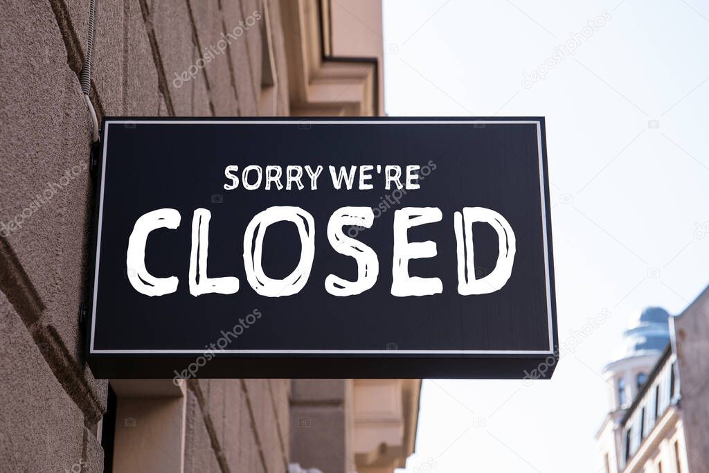 Sorry, were closed. Black advertising sign on the wall of the house