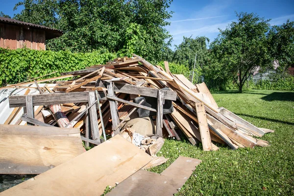 Houten brokstukken op de binnenplaats, planken en borden. Bouw en wederopbouw — Stockfoto