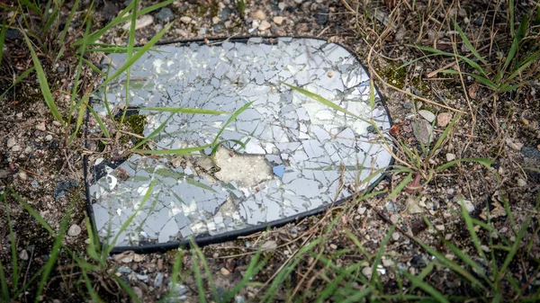 Beaten car mirror in small peaces on the ground after accident — Stock Photo, Image