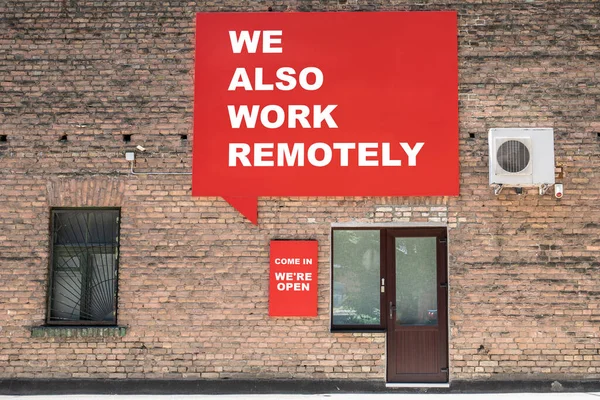 WE ALSO WORK REMOTELY. COME IN WERE OPEN. Advertising banner and information on the wall. Sales and service