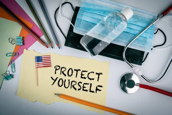 PROTECT YOURSELF. Covid-19 penyebaran virus. Topeng wajah, pembersih tangan dan stetoskop dengan bendera — Stok Foto