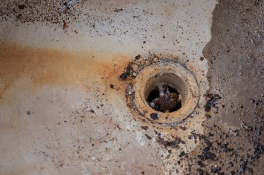 Eski paslı demir küvetin dibi.