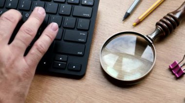 Arama ve çalışma konsepti. Masaya klavye büyüteci ve kalem yazıyorum.