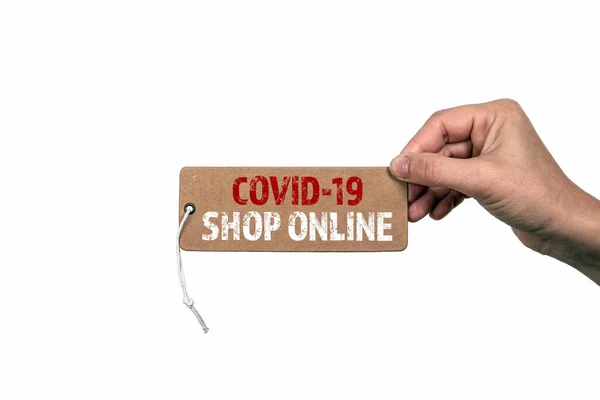 COVID-19 SHOP ONLINE. Etiqueta de preço com uma corda em uma mão de mulher. Temporada, lojas, pedidos e entregas online — Fotografia de Stock