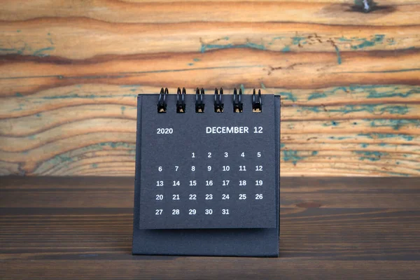 2020 DECEMBER. Black paper calendar on a wooden table. Time plannin
