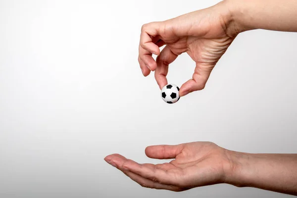 Miniatuur voetbal in de hand van vrouwen. Populair sport, entertainment, business en lifestyle concept — Stockfoto