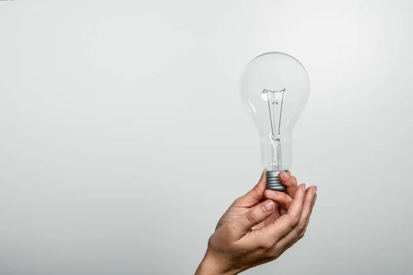 Light bulb in a womans hands. Free space for text and copy space — Stock Photo, Image