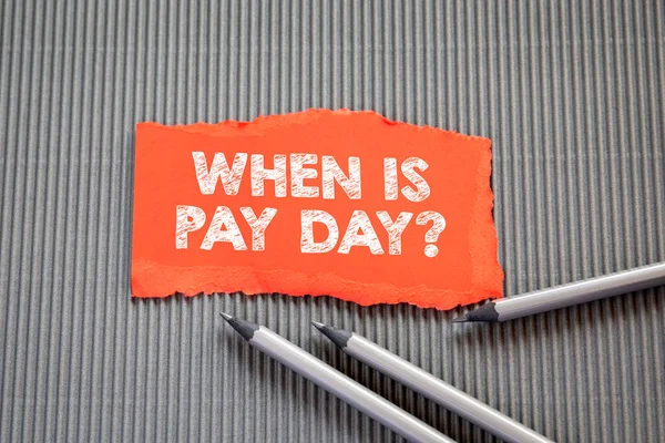 PAY DAY concept. Text on torn, colored paper on corrugated background