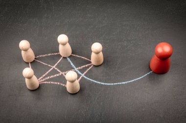 Tek yönlü iletişim ve sosyal dışlanmanın kavramsal görüntüsü ahşap figürler ve tebeşirle çizilmiş oklarla izole bağlantılar oluşturur..