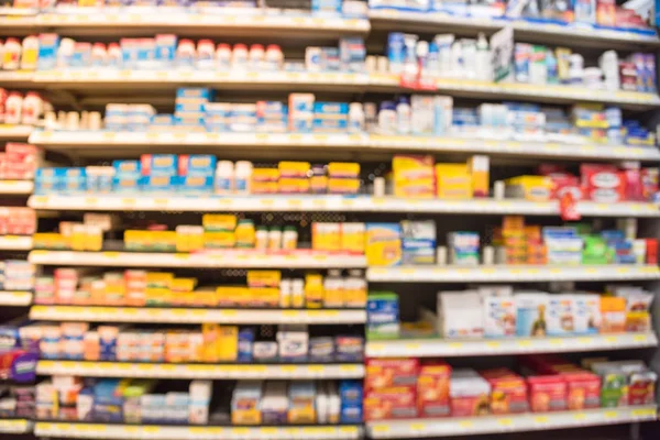Eczane deposu ile ilaç ve tıbbi sarf malzemeleri ürün rafları ekranda etiketindeki görücü usulü varyasyonu içinde arka plan bulanık. İlaç deposu bulanık ilaçlar ile kapalı alanı.
