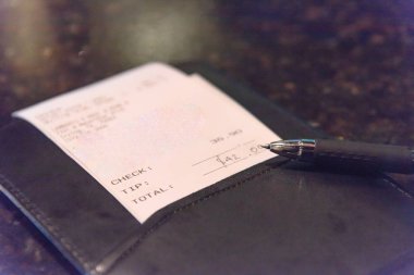 Deri onay yuvasını Restoran bill ve kalem ile açın. Üstten görünüm, yumuşak odak alış irsaliyesiyle mermer çubuğunda veya pub tablo toplam tutar. Müşteri ödeme servis yemek için