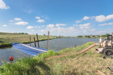 Yakın çekim şişme baraj ve su aktarma için endüstriyel pompa. İnşaat Mühendisliği projeler Irving, Texas, ABD şişirilmiş bariyer. Su silindirik tüp kauçuk, sınıf geo-tekstil malzeme dolu