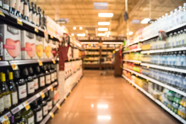 Blurred image wine shelves with price tags on display at store in Houston, Texas, US. Defocused rows Wine Liquor bottles on supermarket shelf. Alcoholic beverage abstract background. Customer shopping