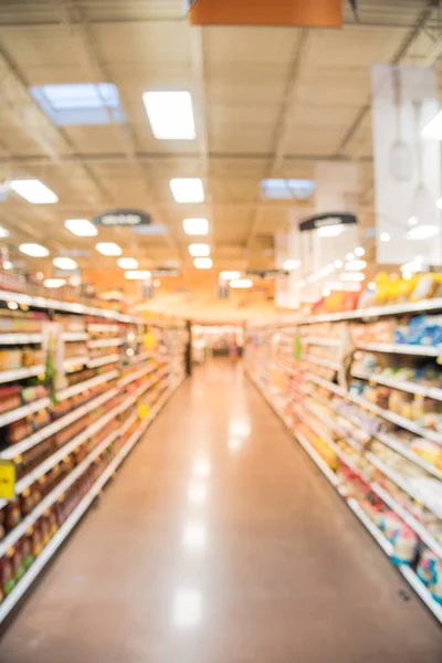 Blurred sauces, buns, rolls, snack, cakes, tortillas, Latin, America, foods, salsa, dips aisle in store at Humble, Texas, US. Wide perspective view shelves variety of foods, defocused blur background