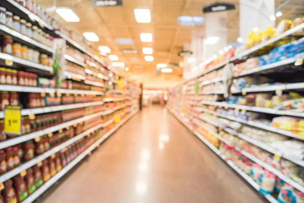 Blurred sauces, buns, rolls, snack, cakes, tortillas, Latin, America, foods, salsa, dips aisle in store at Humble, Texas, US. Wide perspective view shelves variety of foods, defocused blur background