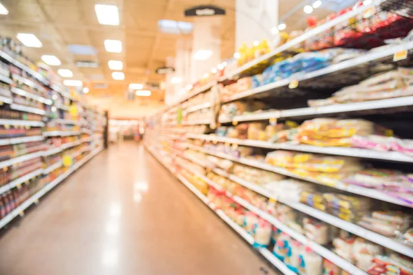 Blurred sauces, buns, rolls, snack, cakes, tortillas, Latin, America, foods, salsa, dips aisle in store at Humble, Texas, US. Wide perspective view shelves variety of foods, defocused blur background