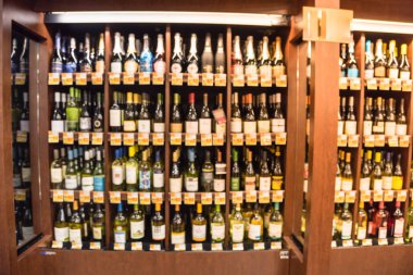 Bulanık görüntü soğutulmuş şarap mağazasında Houston, Texas, büyük çift kişilik şarap koridor bölümünde bize. Ufuk satır süpermarket ahşap raf şarap likör şişeleri. Alkollü içecek arka plan