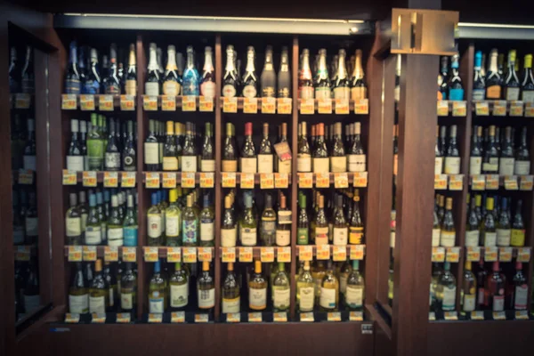 Vintage bulanık büyük çift kişilik şarap koridorda mağazasında Houston, Texas, soğutulmuş şarap bölümünde bize. Şarap likör şişesi süpermarket ahşap raf ufuk satırı. Alkollü içecek arka plan