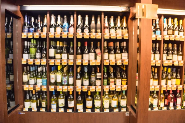 Bulanık görüntü soğutulmuş şarap mağazasında Houston, Texas, büyük çift kişilik şarap koridor bölümünde bize. Ufuk satır süpermarket ahşap raf şarap likör şişeleri. Alkollü içecek arka plan