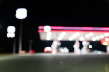 Benzin İstasyonu ile geceleri yakıt ikmali araba bulanık görüntü. , Odak benzin istasyonu ve alacakaranlık markette defocused. Benzin istasyonu arka plan kopya alanı ile bulanıklık.