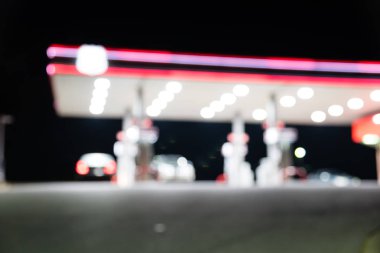 Benzin İstasyonu ile geceleri yakıt ikmali araba bulanık görüntü. , Odak benzin istasyonu ve alacakaranlık markette defocused. Benzin istasyonu arka plan kopya alanı ile bulanıklık.