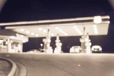 Vintage geceleri yakıt ikmali araba ile benzin istasyonu görüntü bulanık. , Odak benzin istasyonu ve alacakaranlık markette defocused. Benzin istasyonu arka plan kopya alanı ile bulanıklık