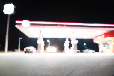 Benzin İstasyonu ile geceleri yakıt ikmali araba bulanık görüntü. , Odak benzin istasyonu ve alacakaranlık markette defocused. Benzin istasyonu arka plan kopya alanı ile bulanıklık.