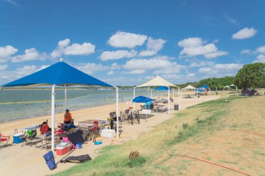 Texas, Usa-Haziran 16, 2018:People zevk grup piknik, Lynn Creek Park, Grand Prairie kamp. Satır katlanır sandalye, Masa, sağlıklı açık yaz etkinlikleri renkli yüksek tepe çadır