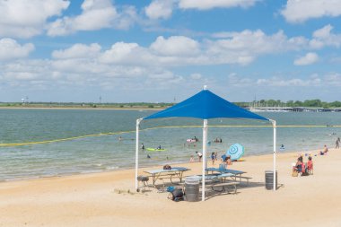Texas, Usa-Haziran 16, 2018: waterfront Lynn Creek Park, Grand Prairie, Texas, güzel beyaz kum plaj. Yüzme, yüzen, grup kamp ve piknik lakeside çadırlar, bulut mavi gökyüzü, insanlar zevk
