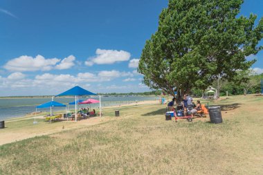 Texas, Usa-Haziran 16, 2018:People grup piknik, kamp alanları, Lynn Creek Park, Grand Prairie barbekü keyfini çıkarın. Katlanır sandalye Kur büyük ağaçlarının, sağlıklı açık yaz etkinlikleri altında kamp çadırları,