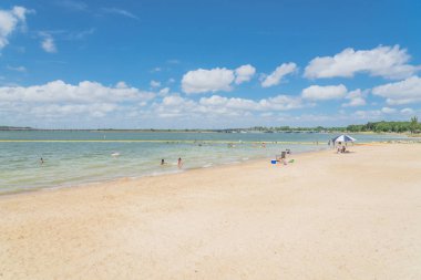 Texas, Usa-Haziran 16, 2018: waterfront Lynn Creek Park, Grand Prairie, Texas, güzel beyaz kum plaj. Yüzme, yüzen, grup kamp ve piknik lakeside çadırlar, bulut mavi gökyüzü, insanlar zevk