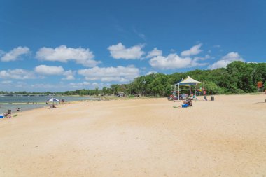 Texas, Usa-Haziran 16, 2018: waterfront Lynn Creek Park, Grand Prairie, Texas, güzel beyaz kum plaj. Yüzme, yüzen, grup kamp ve piknik lakeside çadırlar, bulut mavi gökyüzü, insanlar zevk