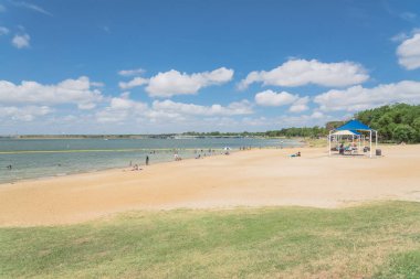 Texas, Usa-Haziran 16, 2018: waterfront Lynn Creek Park, Grand Prairie, Texas, güzel beyaz kum plaj. Yüzme, yüzen, grup kamp ve piknik lakeside çadırlar, bulut mavi gökyüzü, insanlar zevk