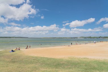 Texas, Usa-Haziran 16, 2018: waterfront Lynn Creek Park, Grand Prairie, Texas, güzel beyaz kum plaj. Yüzme, yüzen, grup kamp ve piknik lakeside çadırlar, bulut mavi gökyüzü, insanlar zevk