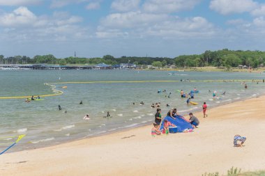 Texas, Usa-Haziran 16, 2018: waterfront Lynn Creek Park, Grand Prairie, Texas, ABD, güzel beyaz kum plaj. Aile üyeleri zevk yüzme, yüzen, grup kamp ve piknik çadırları ayarlama