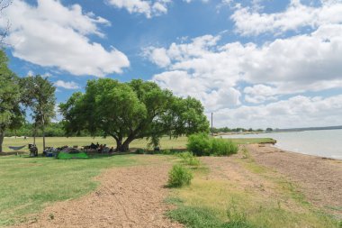 Texas, Usa-Haziran 16, 2018:People grup piknik, kamp alanları, Lynn Creek Park, Grand Prairie barbekü keyfini çıkarın. Katlanır sandalye Kur büyük ağaçlarının, sağlıklı açık yaz etkinlikleri altında kamp çadırları,