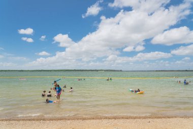 Texas, Usa-Haziran 16, 2018:People yüzme, Lynn Creek Park waterfront adlı yüzen tadını çıkarın. Güvenli yüzme alanı oluşturmak için oluşturmak için göl boyunca sarı şişme şamandıra işaretleri. Güneşli yaz bulut mavi gökyüzü