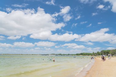 Texas, Usa-Haziran 16, 2018: waterfront Lynn Creek Park, Grand Prairie, Texas, güzel beyaz kum plaj. Yüzme, yüzen, grup kamp ve piknik lakeside çadırlar, bulut mavi gökyüzü, insanlar zevk