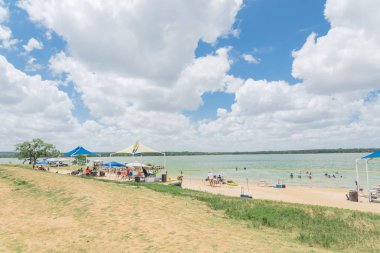 Texas, Usa-Haziran 16, 2018: waterfront Lynn Creek Park, Grand Prairie, Texas, güzel beyaz kum plaj. Yüzme, yüzen, grup kamp ve piknik lakeside çadırlar, bulut mavi gökyüzü, insanlar zevk