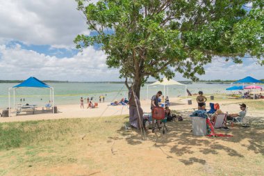 Texas, Usa-Haziran 16, 2018:People grup piknik, kamp alanları, Lynn Creek Park, Grand Prairie barbekü keyfini çıkarın. Katlanır sandalye Kur büyük ağaçlarının, sağlıklı açık yaz etkinlikleri altında kamp çadırları,