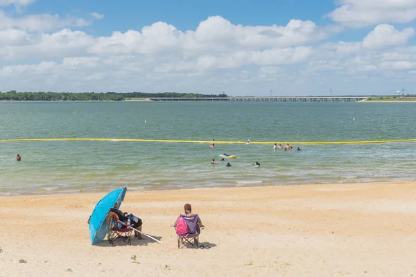 Texas, Usa-Haziran 16, 2018: waterfront Lynn Creek Park, Grand Prairie, Texas, güzel beyaz kum plaj. Yüzme, yüzen, grup kamp ve piknik lakeside çadırlar, bulut mavi gökyüzü, insanlar zevk